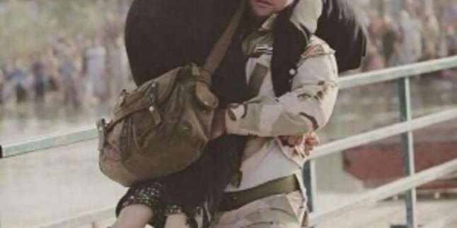 Foto: Iraklı Şii asker, Ambar’lı Sünni bir anneyi yürüyemediği için 50 derecelik sıcakta sırtlanmış götürüyor